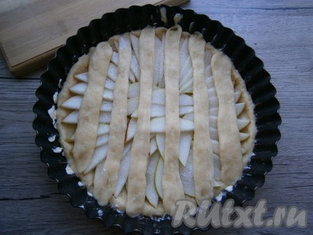 Оставленную часть теста разделить на несколько частей, каждую скатать в длинную полоску, приплюснуть. Накрыть полосами начинку из груш.