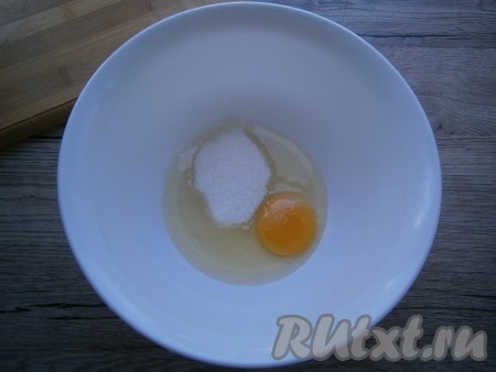 К сахару добавить сырое яйцо и щепотку соли.