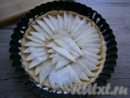 Груши нарезать тонкими дольками, удалив сердцевину, выложить их по кругу формы с тестом. Посыпать груши сахаром.
