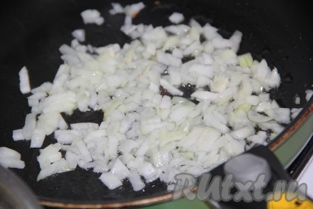 В сковороду влить растительное масло, добавить лук и обжарить его на среднем огне до золотистого цвета, не забывая иногда перемешивать.
