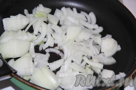 Лук очистить, нарезать на тонкие четверть кольца. В сковороду влить немного масла, добавить лук и обжарить его до золотистого цвета (в течение 4-5 минут), иногда помешивая, на среднем огне.