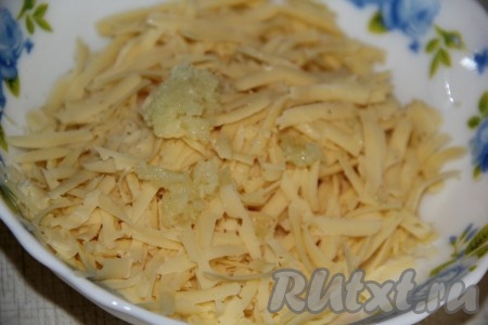 Для приготовления заливки чеснок очистить, пропустить через пресс. В отдельной тарелке соединить чеснок с сыром, натёртым на крупной тёрке.