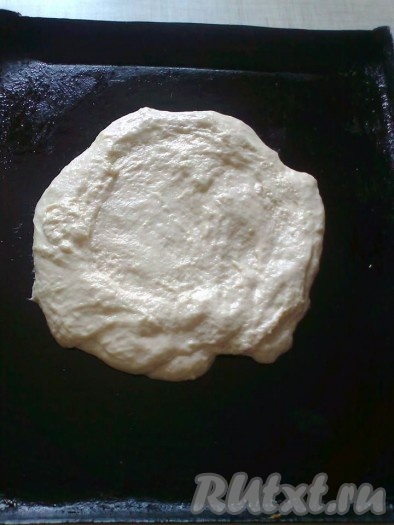 Тесто равномерно поливаем сверху 1 чайной ложкой растительного масла и с помощью столовой ложки разравниваем тесто в круг.