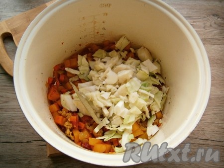 Все перемешать, добавить нарезанную кусочками капусту, измельченный чеснок и лавровый лист. Рагу перемешать, крышку мультиварки закрыть и продолжать тушение до сигнала.
