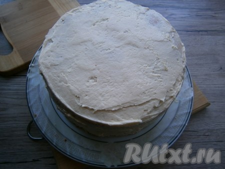 Смазать прослоенные джемом части бисквита кремом (слой делать не слишком толстым). Выложить части бисквита, смазанные кремом, друг на друга, формируя торт. Верх и бока торта выровнять этим же кремом. Тортик отправить в холодильник на пару часов.
