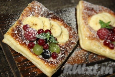 Аппетитные, вкусные слойки с кремом, украшенные фруктами и ягодами, посыпать сверху сахарной пудрой и подать к столу. Отличная выпечка, попробуйте!
