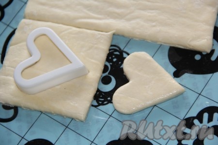 С помощью любой вырубки (формочки для печенья) вырезать на одном квадратике отверстие. Каждая слойка будет состоять из двух квадратиков - один квадрат (без отверстия) станет основанием слойки, а квадратик с вырезанным отверстием - бортиком. 
