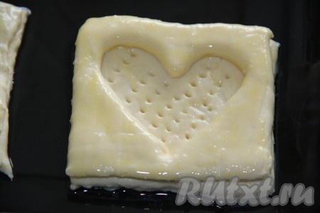 Тесто поднимется. Перед выпеканием смазать верх теста взбитым желтком или молоком. Наколоть дно слойки вилкой (как на фото). Выпекать в духовке, разогретой до 180 градусов, примерно, 15 минут.
