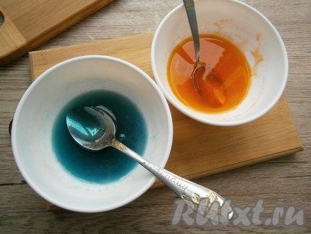 Разделить желатин на 2 части, разлив его по двум пиалам. В каждую пиалу добавить сухой или гелевый пищевой краситель любого цвета (у меня - оранжевый и синий), перемешать красители с желатином до однородности. Сухого красителя добавляйте на кончике ножа, гелевого - по 3-4 капли.
