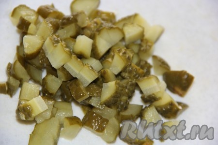 Нарезать солёные огурцы на кубики среднего размера или на кружки.
