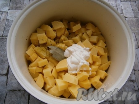 К почти готовому кролику добавить очищенный и нарезанный кубиками или кусочками картофель, сметану, лавровый лист, всыпать соль, приправу, влить 200 мл горячей воды, закрыть крышку мультиварки.
