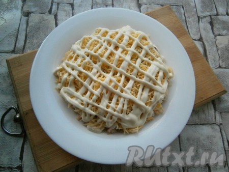 На орехи выложить слой натертого на крупной или средней терке сыра (лучше выбирать сыр не пресный). Также на сыр нанести сетку из майонеза. По желанию, слои салата можно повторить, увеличив количество продуктов.
