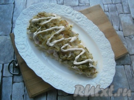 Следующим слоем выложить натертый на крупной терке и отжатый маринованный или соленый огурчик + майонез.