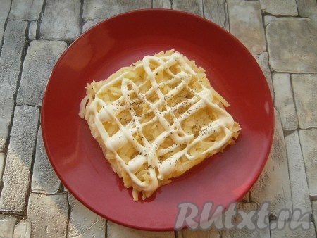 Вареный картофель очистить и натереть на средней терке. Выложить картошку на тарелку в виде квадрата или прямоугольника, смазать майонезом, немного посолить и поперчить.
