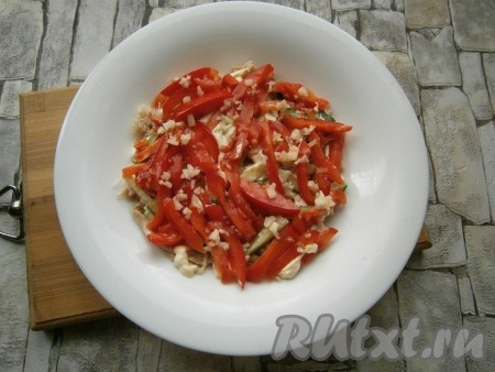 Далее выложить слой большей части помидоров, нарезанных брусками или длинными кусочками, на них - половину измельченного чеснока, немного посолить.
