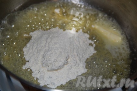 В толстостенную кастрюлю выложить сливочное масло и растопить, уменьшить огонь. Затем всыпать муку.