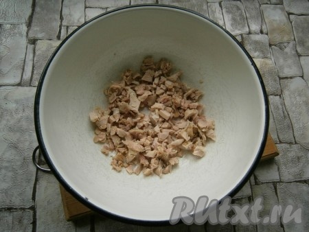 Отваренное в подсоленной воде в течение 40 минут и охлажденное куриное мясо нарезать кусочками.