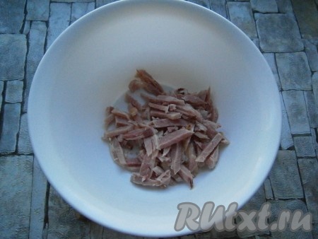 Копченый окорочок отделить от костей, а затем куриное мясо нарезать брусочками или порвать руками на волокна.