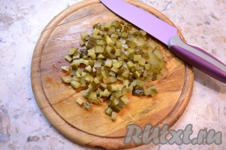 Маринованный огурец нарезать небольшими кубиками.
