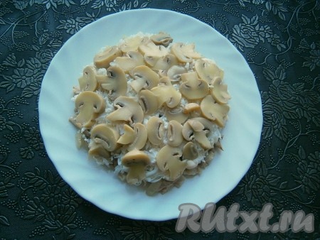 Яйца разделить на белки и желтки. Белки натереть и выложить следующим слоем, на них - нарезанные тонкими пластинами маринованные шампиньоны.
