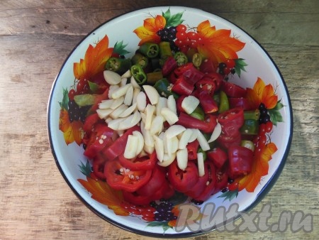 Сладкий перец нарежьте вместе с семенами колечками шириной 0,5-1 см. С острым перцем лучше работать в перчатках, будьте осторожны, чтобы его сок не попал в глаза при нарезке. Острый перец нарежьте, не очищая от семян, на колечки шириной 2-3 см. Чеснок нарежьте на лепестки.
