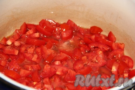 Лук и морковь очистить, из болгарских перцев удалить семенную коробку. В глубокую кастрюлю влить растительное масло. Помидоры вымыть, нарезать на средние кусочки и выложить в кастрюлю с маслом.
