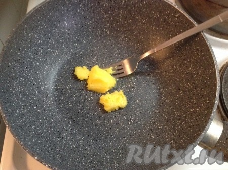 Сковороду ставим на огонь, растапливаем топленое масло и добавляем очищенный чеснок, нарезанный на лепестки.