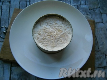 Далее выложить сыр, натертый на средней или мелкой терке, смазать майонезом, разровнять.
