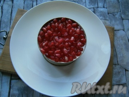 Последним слоем выложить зерна граната, чуть их придавливая.