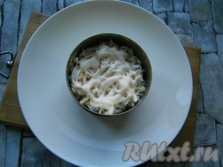 На грецкие орехи выложить вареное яйцо, натертое на терке, смазать майонезом.
