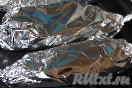 Аналогично заполнить брюшко второй скумбрии оставшейся начинкой и тоже завернуть рыбу в фольгу. Обе рыбки, завёрнутые в фольгу, выложить на противень.