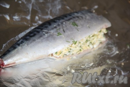 Вначале одну скумбрию выложить на кусок фольги, наполнить брюшко рыбки половиной сырно-яичной начинки. Тщательно завернуть скумбрию в фольгу.