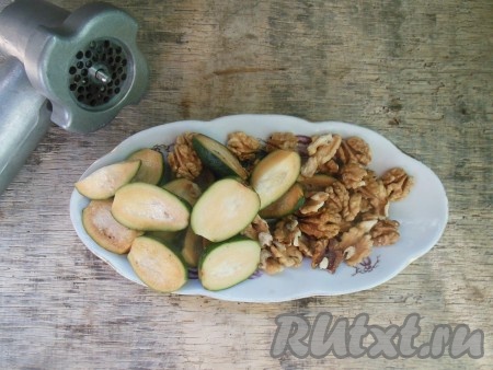 Грецкие орехи очистите от кожуры или используйте уже очищенные. Промойте плоды фейхоа, обсушите, затем разрежьте на две половинки, удалите нижнюю и верхнюю часть с чашелистиками. Так как в разрезанном виде фейхоа быстро темнеет, делать заготовку необходимо быстро.
