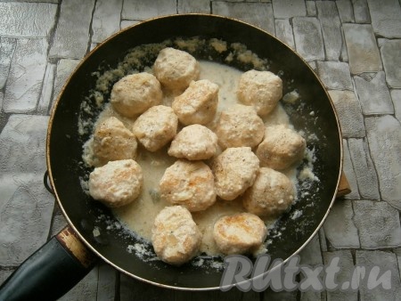 Добавить кусочек сливочного масла, сковороду накрыть крышкой. Тушить куриные шарики в сливочном соусе на небольшом огне около 10-15 минут. В конце их можно перемешать.

