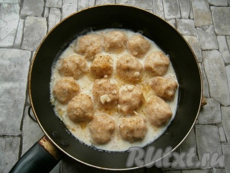 Влить теплые сливки, посолить соус, посыпать специями, добавить очищенный и измельченный чеснок.
