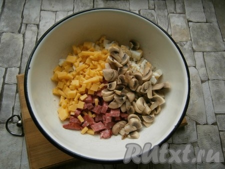 Сыр нарезать маленькими кубиками. Маринованные шампиньоны нарезать и вместе с кубиками сыра добавить в салат из колбасы и яиц.
