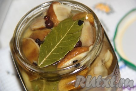 Снять маринад с огня и горячим маринадом залить грибы в банках.
