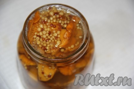 Горячим маринадом залить баночку с лисичками до самого верха.