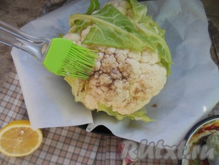 С помощью силиконовой кисточки обмажьте кочан цветной капусты смесью растительного масла, чеснока, соли, черного перца и лимонного сока.
