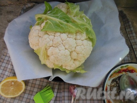Форму для запекания застелите пергаментом. Поместите в форму цветную капусту кочерыжкой вниз.
