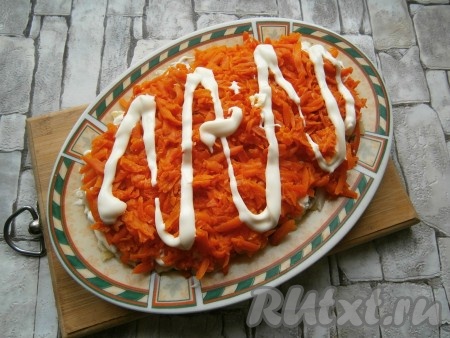 Этот слой также смазать майонезом, далее выложить слой очищенной моркови, натёртой на крупной тёрке, нанести майонез.