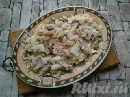 Смазать картофель майонезом, вторым слоем выложить скумбрию, нарезанную на кусочки, и мелко нарезанный очищенный репчатый лук.