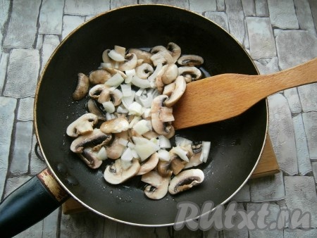 Обжарить грибы на небольшом огне несколько минут, после чего добавить очищенный и нарезанный не крупно репчатый лук. Обжаривать далее минут 5, периодически помешивая. Грибы с луком немного посолить, остудить.
