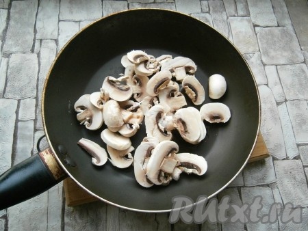 Шампиньоны нарезать пластинами, поместить в сковороду с растительным маслом.
