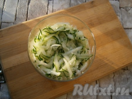 Свежий огурец вымыть, обсушить, натереть на крупной тёрке, равномерно разложить следующим слоем по трём стаканчикам, немного посолить, смазать частью сметанно-майонезного соуса.