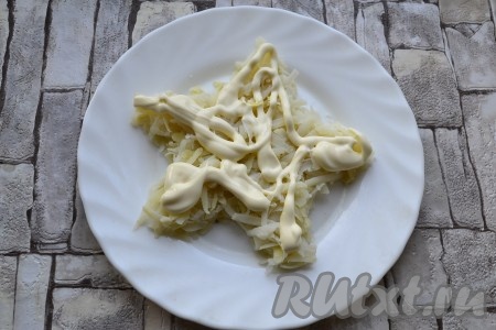 Картофель очистить и натереть на средней терке, выложить слой картошки в виде звезды на тарелку, посолить, смазать майонезом.
