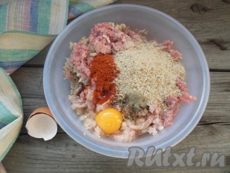 Добавьте в фарш куриное яйцо, соль по вкусу, черный молотый перец, паприку и панировочные сухари.
