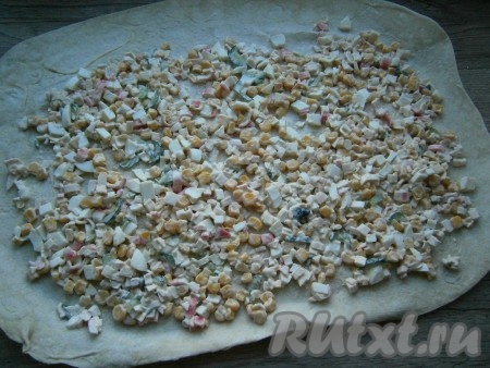 Лист лаваша разложить на столе и выложить по всей его поверхности крабовый салат, оставляя края лаваша чистыми (как на фото).
