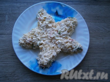 Выложить салат на плоскую тарелку в виде звезды.