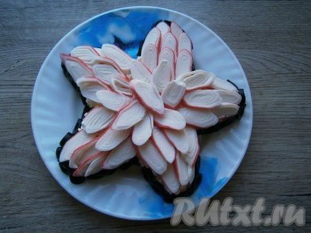 Бока салата "Морская звезда", для того чтобы блюдо выглядело более эффектно, можно украсить чёрными оливками, нарезанными на колечки.
